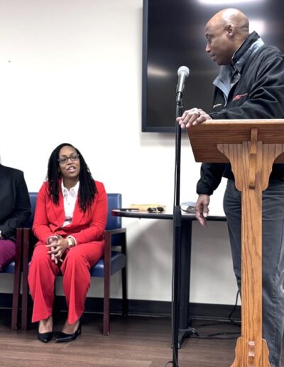 Chanae Clemons, Bianja Smith sitting while Chairman Jeff Turner speaks