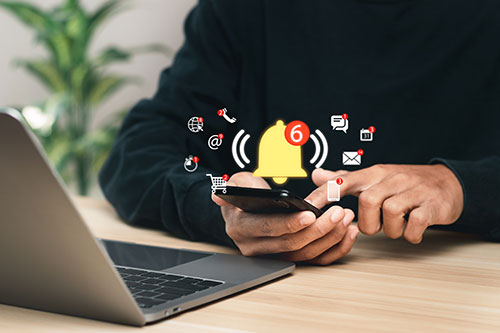 Man looking at phone with multiple notifications popping out